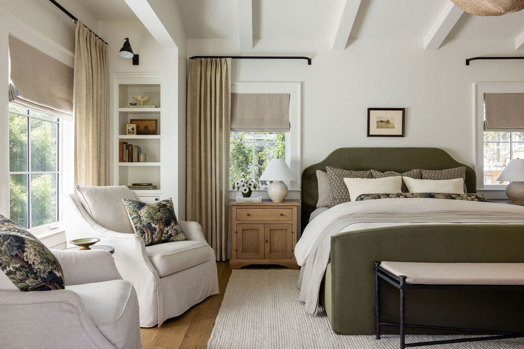 A photo of a night stand in a master bedroomwith a large window and a bed with a large headboard